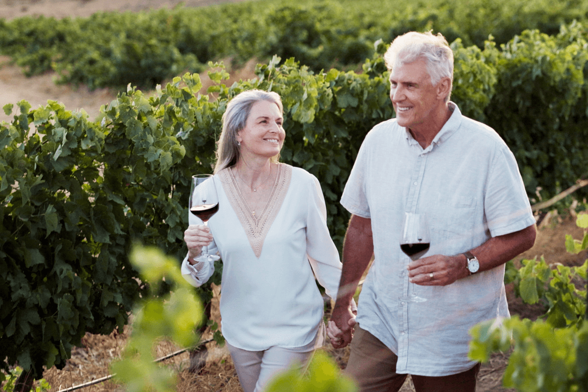 happy married couple walking in winelands